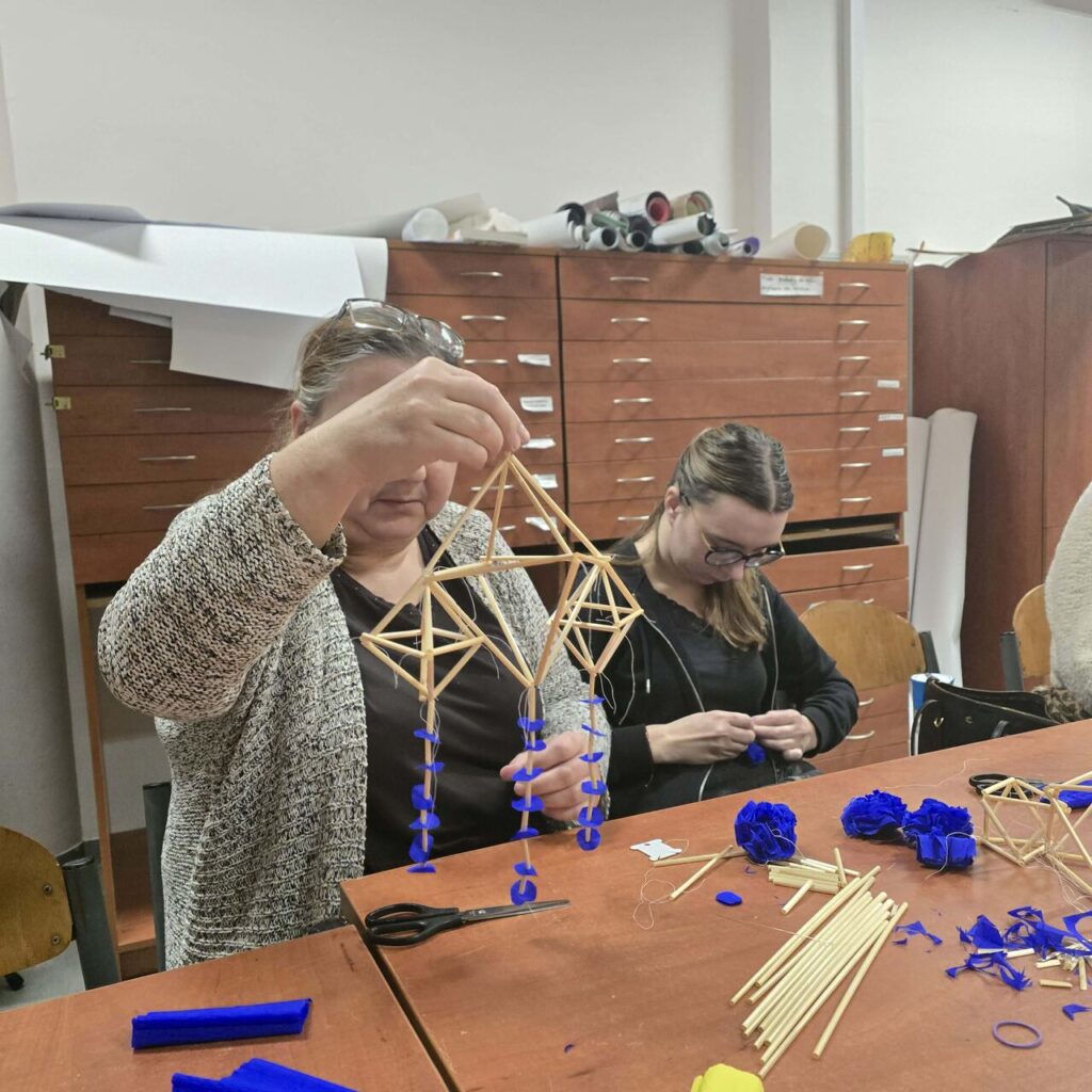 Zbliżenie na efekt warsztatów -pająka ludowego wykonanego z naturalnej słomy i kolorowej bibuły – symbolu szczęścia w kulturze ludowej.