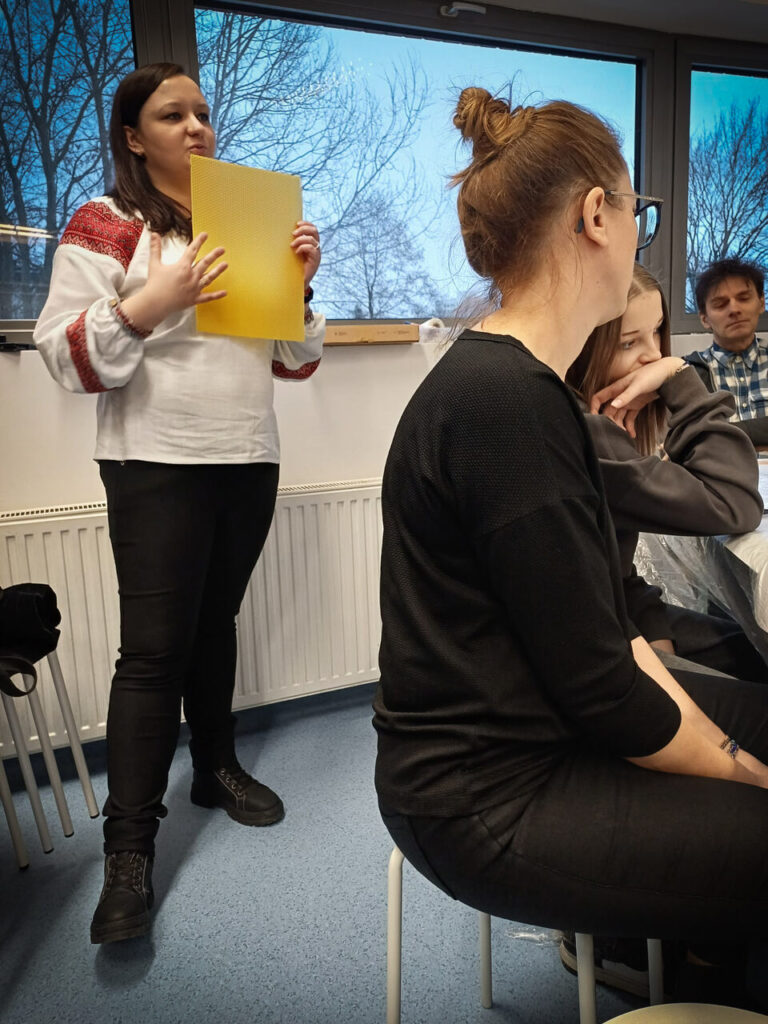 Prowadząca warsztaty Marlena Jurczak opowiada o symbolice pszczół i medycynie ludowej związanej z woskiem.